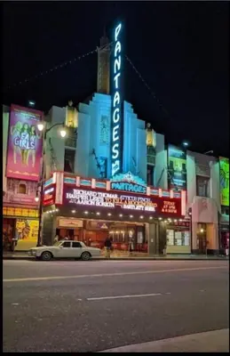 a car parked in front of a theater at night at Hollywood Penthouse with Balcony & Pool View in Los Angeles