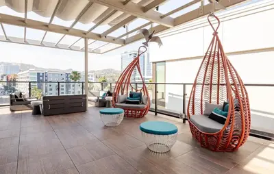 a room with two hanging chairs on a balcony at Hollywood Penthouse with Balcony & Pool View in Los Angeles