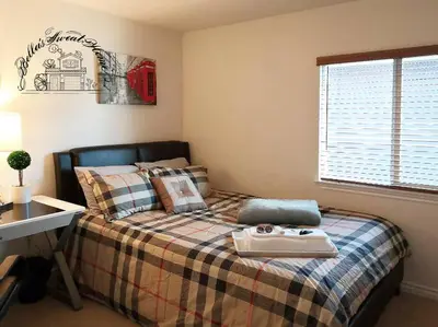 a bedroom with a bed with a desk and a window at Bella's sweet house 5608 in Eastvale