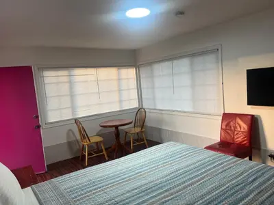 a bedroom with a bed and a table and chairs at Silver Sands Motel in Ventura