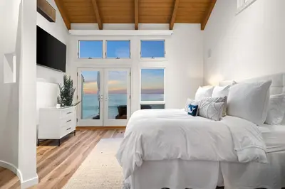 a white bedroom with a large bed and a window at Coastal Serenity in Malibu