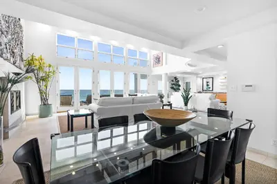 a living room with a glass table and chairs at Coastal Serenity in Malibu
