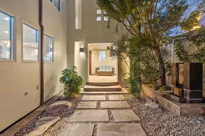 a walkway leading to a house with a tree at Coastal Serenity in Malibu
