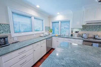 a large kitchen with white cabinets and windows at Amazing days Spa Pool Villa near Disney & Beaches in Placentia