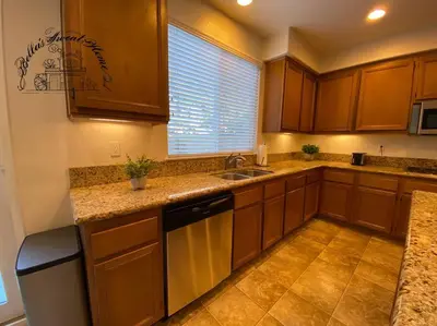 a kitchen with wooden cabinets and a sink and a window at Bella's sweet house 5640 in Eastvale