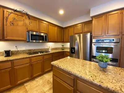 a kitchen with wooden cabinets and stainless steel appliances at Bella's sweet house 5640 in Eastvale