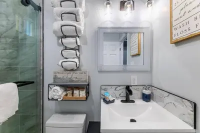 a bathroom with a sink and a toilet and towels at Luxe and Modern South Bay ADU in Carson