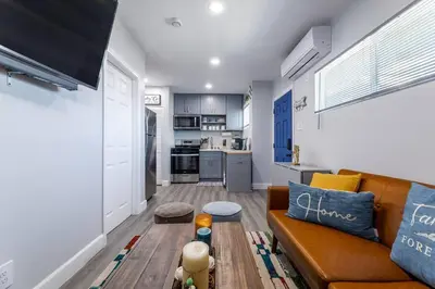 a living room with a couch and a kitchen at Luxe and Modern South Bay ADU in Carson