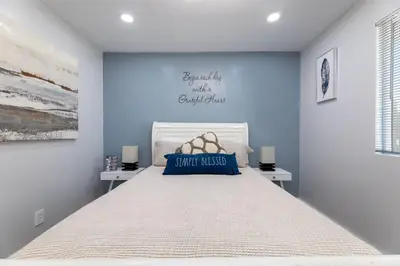 a bedroom with a large bed with a blue wall at Luxe and Modern South Bay ADU in Carson