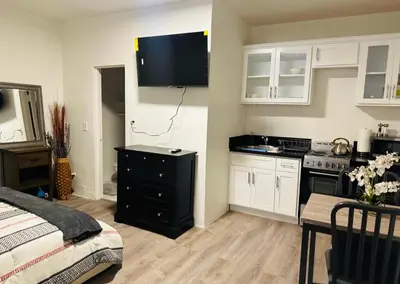 a kitchen with a black dresser with a television on the wall at Sunset & La brea studio!! Best location ever in Los Angeles