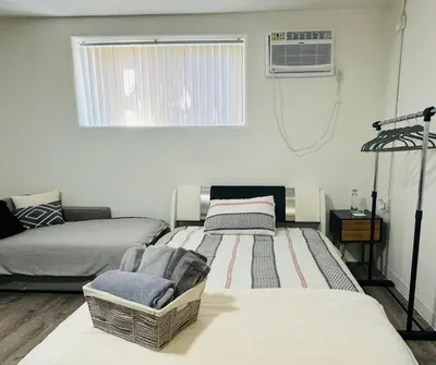 a living room with three beds and a window at Sunset & La brea studio!! Best location ever in Los Angeles