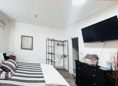a bedroom with a bed and a flat screen tv at Sunset & La brea studio!! Best location ever in Los Angeles