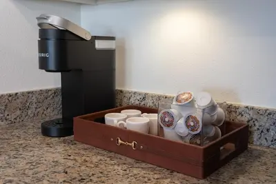 a tray of coffee cups and a coffee machine at Charming 2bd Condo on SunsetStrip in Los Angeles