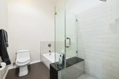 a bathroom with a toilet and a glass shower at Ultimate LA Vacation 2BR w Pool Above Shops in Monterey Park