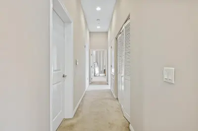 a hallway with white walls and a white door at Ultimate LA Vacation 2BR w Pool Above Shops in Monterey Park