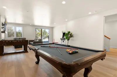a pool table in a living room with a pool table at Pine Meadow - Game Room with pool table, foosball & shuffleboard! in Big Bear Lake