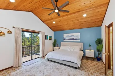 a bedroom with a bed and a ceiling fan at North Shore Chalet Lake View, Spa and Game Rooms in Fawnskin