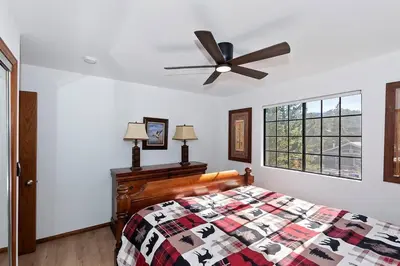 a bedroom with a bed and a ceiling fan at North Shore Chalet Lake View, Spa and Game Rooms in Fawnskin