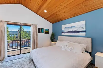 a bedroom with a bed and a large window at North Shore Chalet Lake View, Spa and Game Rooms in Fawnskin