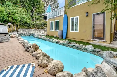 a swimming pool with rocks around a house at NEW BEACH Pool Home, New Industrial OCEAN Vibe, Hot Tub, Pool, Views in El Segundo