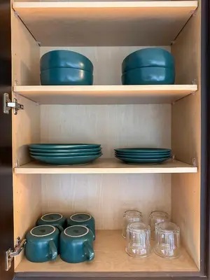 a wooden cabinet with blue bowls and glasses in it at City View Suite - DTLA by Monthier in Los Angeles