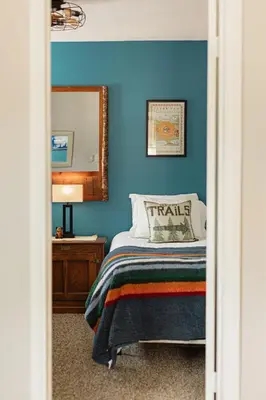 a bedroom with blue walls and a bed with a mirror at Blissful Bay Cabin in Big Bear Lake