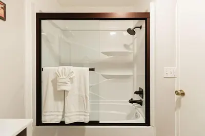 a bathroom with a shower with white towels at Blissful Bay Cabin in Big Bear Lake