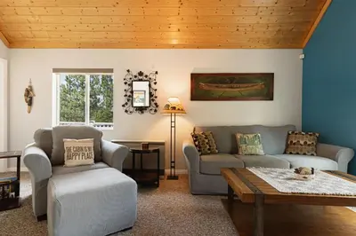a living room with two couches and a table at Blissful Bay Cabin in Big Bear Lake
