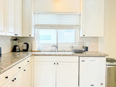 a kitchen with white cabinets and a sink and a window at Diamond in Los Angeles- AM3 in Los Angeles