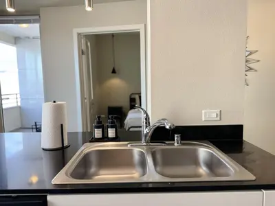 a stainless steel sink in a kitchen with a mirror at Stylish 1 Bedroom Apartment in LA with Free Parking - 10 Minutes away from Ceders Sinai in Los Angeles