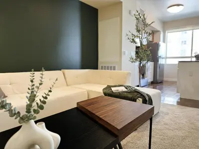a living room with a white couch and a table at Stylish 1 Bedroom Apartment in LA with Free Parking - 10 Minutes away from Ceders Sinai in Los Angeles