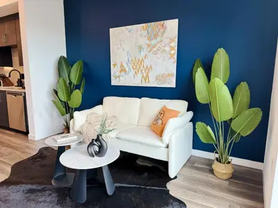 a living room with a white couch and blue wall at Cosmopolitan Hollywood Home DTLA view Parking - 10mins to Universal Studios in Los Angeles