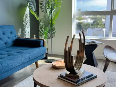 a living room with a blue couch and a table at Modern Hollywood Home Sunset View & Free Parking - 10mins to Universal Studios in Los Angeles