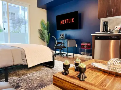 a bedroom with a bed and a kitchen with a tv at Cozy Home in LA - Free Parking 10 Min to Cedars in Los Angeles