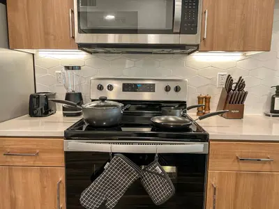 a kitchen with a stove with two pots and a microwave at Luxurious Hollywood Home City View - Free Parking 10mins to Universal Studios in Los Angeles