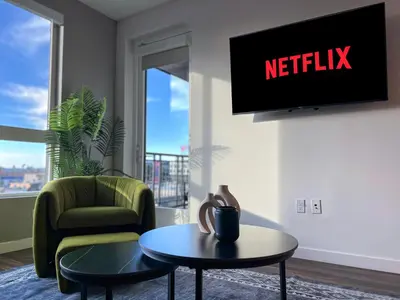 a living room with a tv and a chair and a table at Luxurious Hollywood Home City View - Free Parking 10mins to Universal Studios in Los Angeles