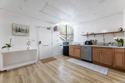 a large kitchen with wooden floors and a large window at Quiet King bed Westward Room in heart of Pasadena in Pasadena