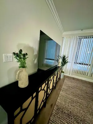a living room with a television and a vase with plants at Shared House Hollywood Hideaway Heart of Fame in Los Angeles
