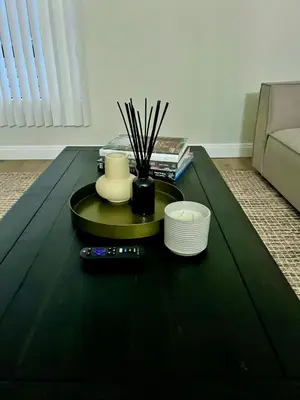 a black coffee table with a remote control and plates at Shared House Hollywood Hideaway Heart of Fame in Los Angeles