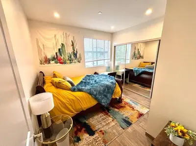 a bedroom with a yellow bed and a living room at FuLLy LoAdeD ReSerVaTioN 3bed 2ba w Parking in Los Angeles