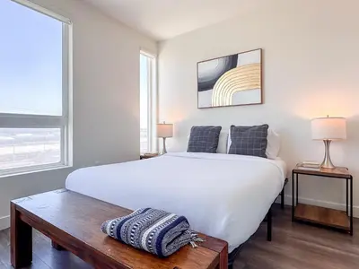 a bedroom with a large white bed and two windows at Monthier Downtown SA5S1U0 in Los Angeles