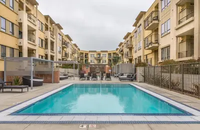a swimming pool in front of some apartment buildings at Monthier LACMA WI4S4U0 in Los Angeles