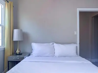 a bed with white sheets and a lamp on a table at Monthier Picfair Village CA1H6O23 in Los Angeles