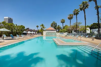 a swimming pool with chairs and palm trees at Monthier LACMA SI5T8H57 in Los Angeles