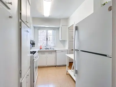 a kitchen with white cabinets and a refrigerator at Monthier LACMA SI5T8H57 in Los Angeles
