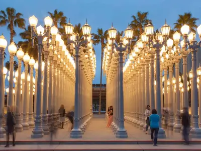 a row of lights on a pier with palm trees at Monthier LACMA SI5T8H57 in Los Angeles
