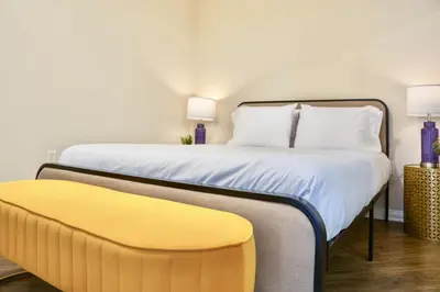 a bedroom with a bed and a yellow bench at Los Angeles Suite LACMA in Los Angeles