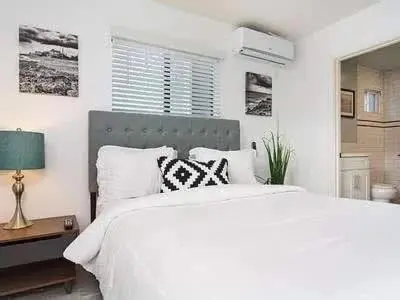 a white bedroom with a large white bed with pillows at Sunny Studio in the Heart of Venice - A in Los Angeles
