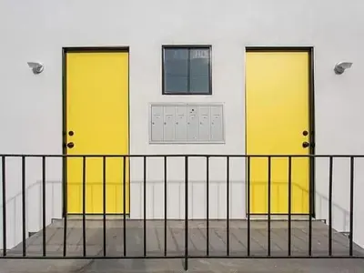 two yellow doors on the side of a building at Sunny Studio in the Heart of Venice - A in Los Angeles