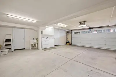 an empty garage with white cabinets and white appliances at Sand Side Bliss in Oxnard
